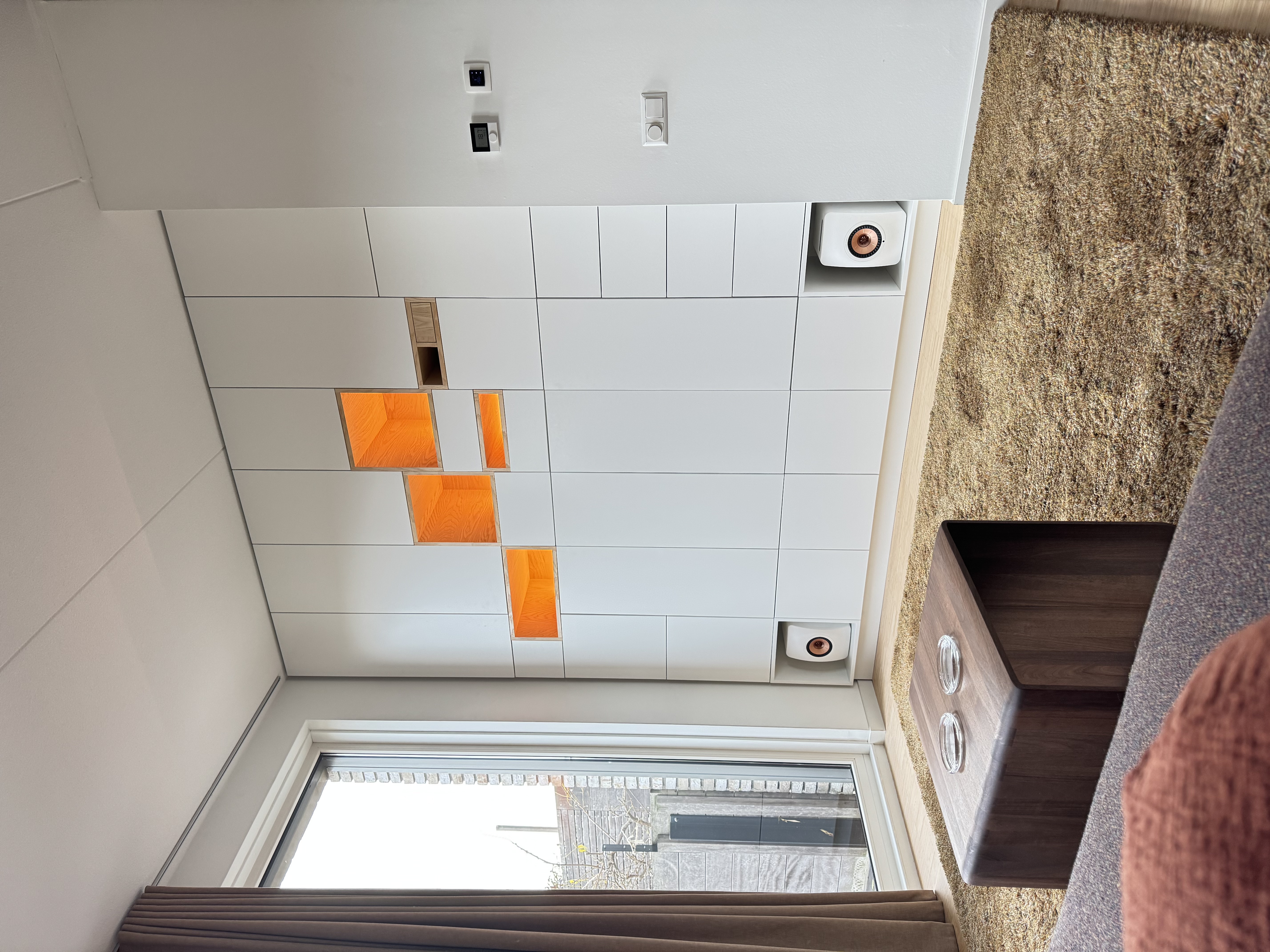 Maatwerk wandkast op maat met oranje verlichte vakken en ingebouwde speakers, woonkamer Groningen — Samsam Interieur